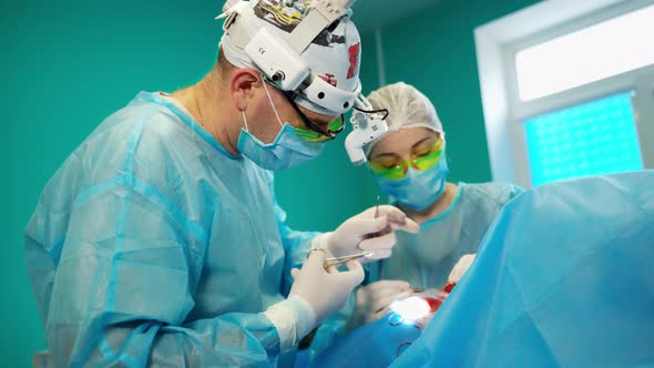 Surgeon and assistant at work. Professional doctors performing operation in surgery room