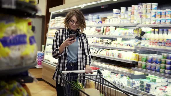 Shopping Technology Sale Consumerism and People Concept Woman with Smartphone and Headphones on Neck