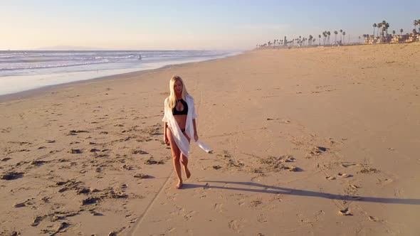Attractive Blond Woman Walking on the Beach