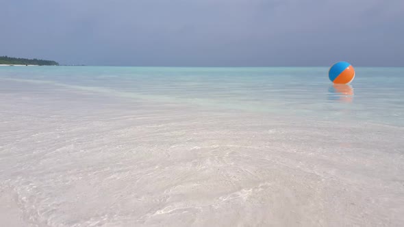 Daytime fly over tourism shot of a summer white paradise sand beach and aqua turquoise water backgro