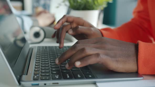 Slow Motion of AfroAmerican Man's Hands Typing Working with Laptop at Desk