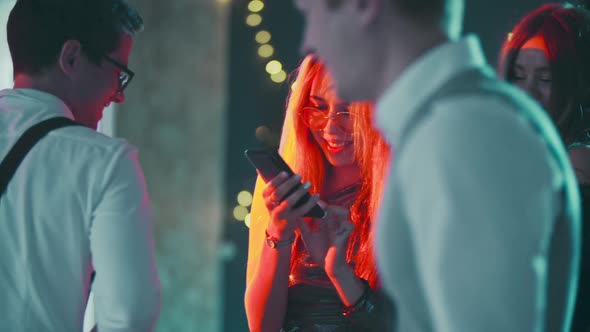 Portrait of Caucasian Blonde Girl Addicted to Phone While Dancing at Party