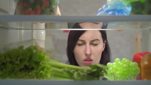 Dissatisfied Female Feels an Unpleasant Smell in the Refrigerator