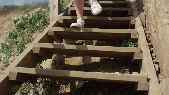 Slim Girl Legs Running Down Beach Staircase Wearing White Sneakers Close Up