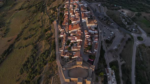 Aerial top-down forward over Monsaraz village on hill at sunset, Portugal