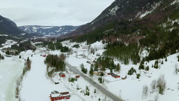 Thick Snow Covering Foot Of Mountain In A Small Village In Haugastol Norway - aerial wide shot