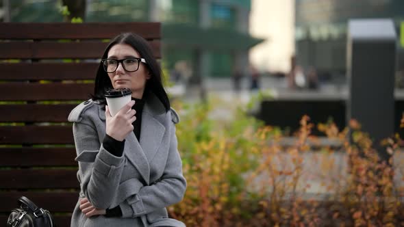 Middleaged Woman is Drinking Coffee in Park in Break Time in Working Day or After Work