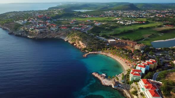 Aerial view dolly in tilt down of the Blue Bay beach in Curacao, Dutch Caribbean island on a sunny d