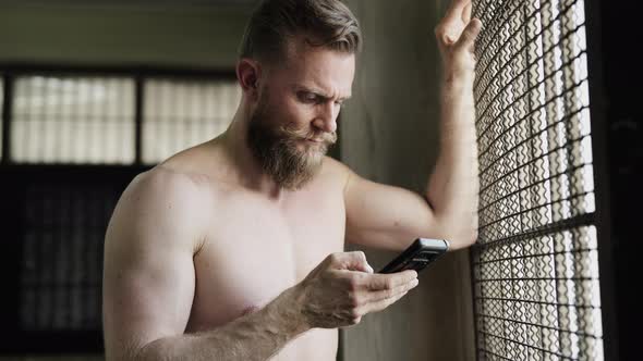 Man with Bandholz Beard Looking on Phone