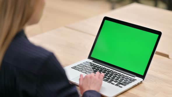 Rear View of Businesswoman Using Laptop with Chroma Screen