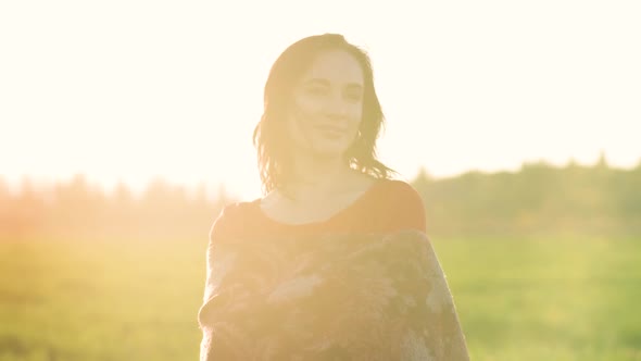 Portrait of a Beautiful Spanish Brunette Woman in a Red Dress at Sunset in a Wheat Field at Day