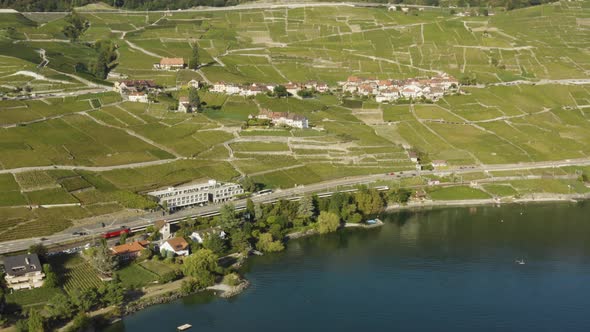 Aerial panning following swiss train traveling along Lake Léman in Lavaux region - SwitzerlandSumme