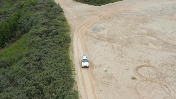 Aerial View of a Car Driving on Sand