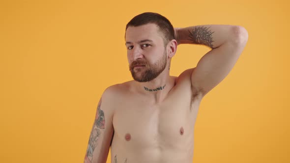 Young Bearded European Man Rubbing Back of His Head Medium Closeup Yellow Background Copy Space