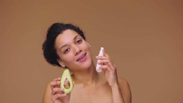 Beauty Portrait Young African American Woman Holding Half an Avocado and Face Cream Natural Skin