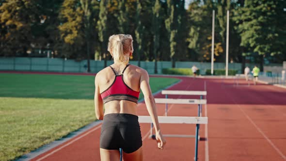 Rear View Sportswoman Female Athlete Jumps Over Obstacles