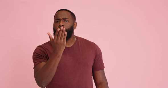 Young African American Man Flirting Isolated on Pink Background