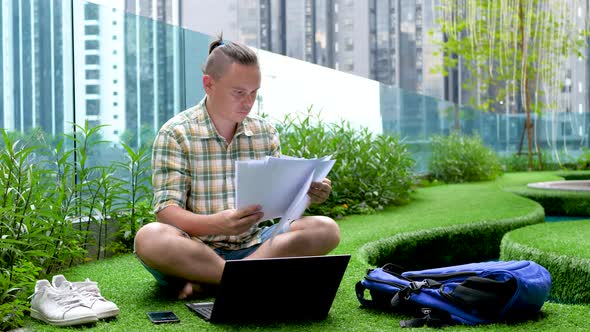 Male Checks Documents And Inputs Data In Laptop Computer