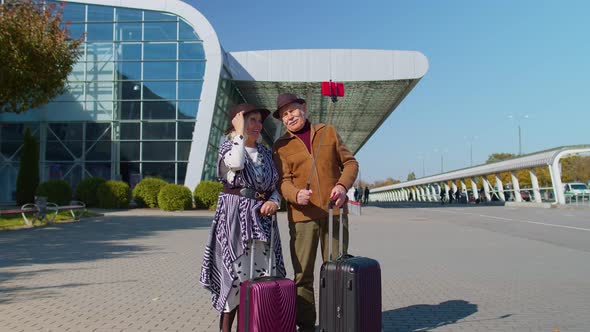 Elderly Husband Wife Retirees Tourists Near Airport Terminal Get Video Call Use Mobile Cell Phone