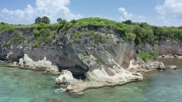 Rocky Coastline Covered in Lush Green Vegetation and Washed with Sea Waters