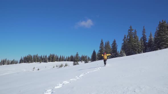 A Man with a Backpack Travels in the Mountains in Winter