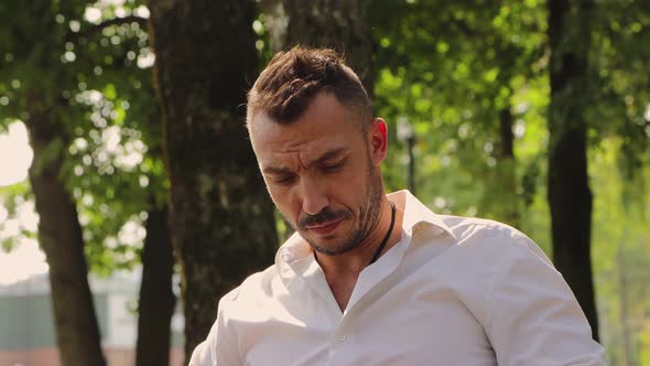 A Business Handsome Man in a White Shirt Speaks on the Phone Drinks Coffee