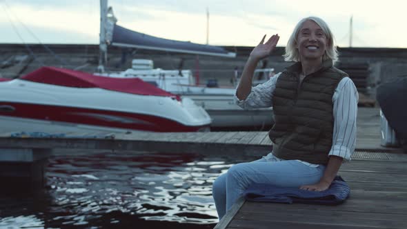 Portrait of Middle-aged Woman Sitting on Embankment