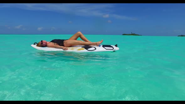 Ladies happy and smiling on tranquil lagoon beach lifestyle by shallow sea with white sandy backgrou