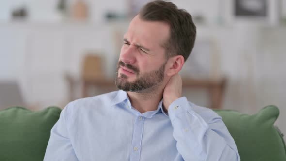 Young Man with Neck Pain at Home