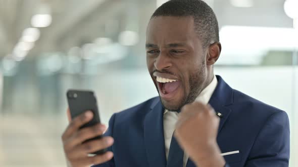 Portrait of African Businessman Having Success on Smartphone 