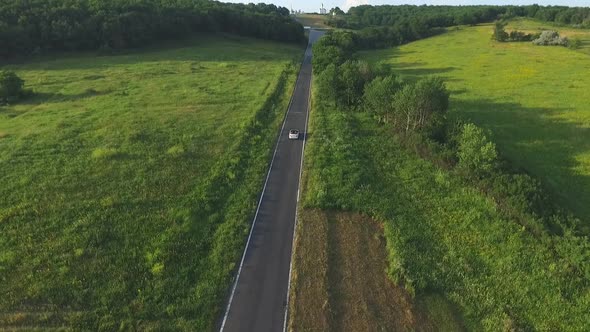 Aerial Shot of White Convertible Car Riding Through Empty Rural Road