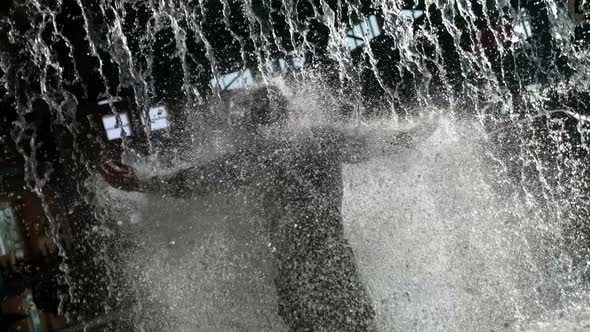 In the Water Park Behind the Waterfall There is a Big Bald Man Doused with Water He is in Swimming