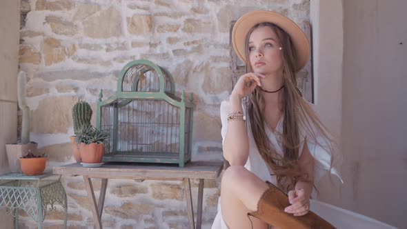 A woman with many braids wearing cowboy boots