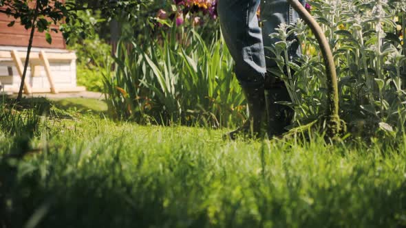 Male Gardener Mowing Green Lawn with Manual Gas Grass Mower Garden Maintenance