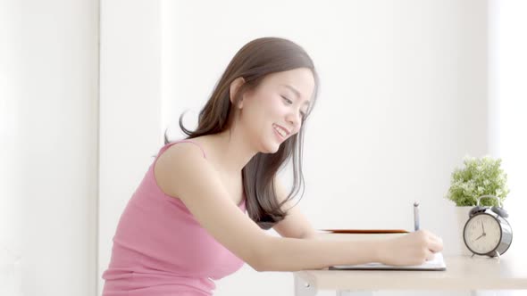 Beautiful young asian woman smiling sitting study and learning writing notebook and diary.