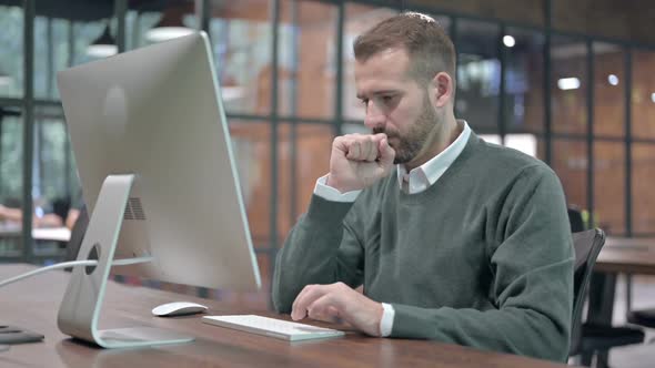 Sick Man Having Coughing While Working on Computer