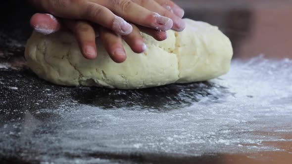 An Experienced Chef in a Professional Kitchen Prepares the Dough  with Flour