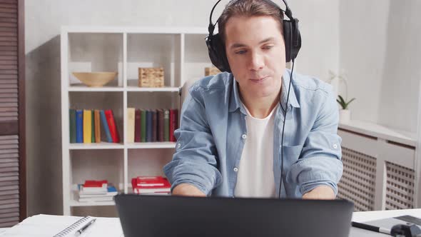 Workplace of freelance worker at home office. Young man works using computer.