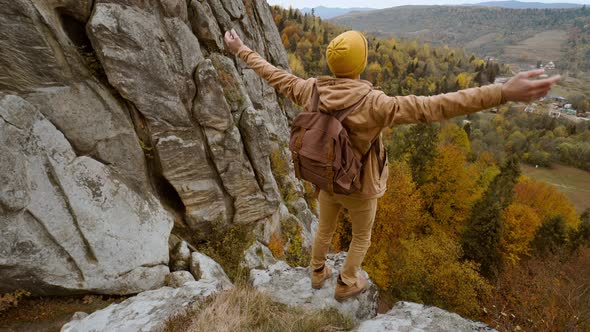 Man Hiker with Backpack Relaxing on Top of a Mountain and Enjoying the View of Valley Tustan Ukraine