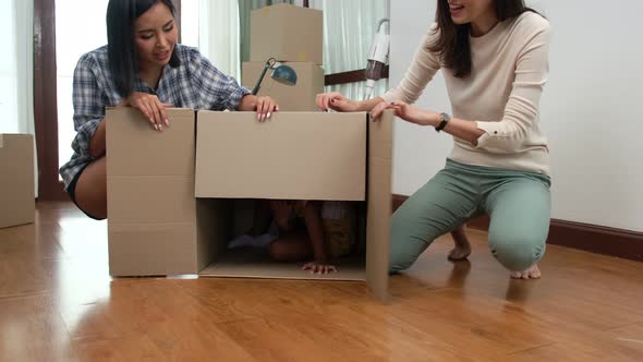 Happy asian women LGBT lesbian couple holding boxes entering new modern house