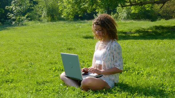 Beautiful Girl Student Working on Laptop in the Park