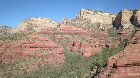 Flying backwards over canyon in red rock landscape