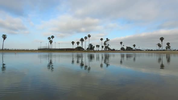 Tracking view of a man paddling his SUP stand-up paddleboard in a lake