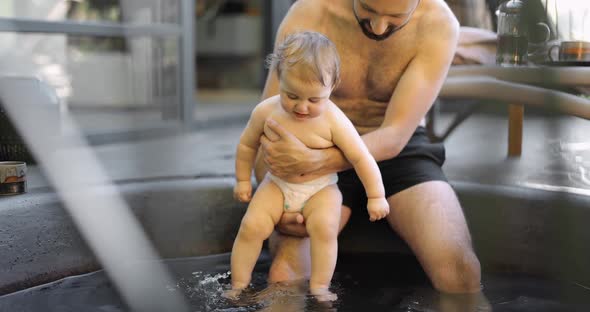 Father Bathing with His Little Baby Son at Spa Outdoors