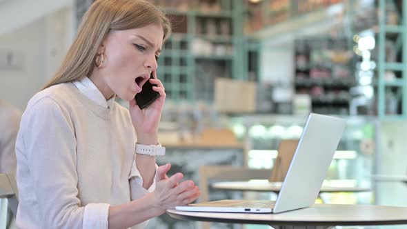 Young Woman Angry on Smartphone in Cafe