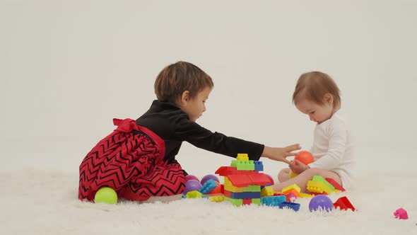 Toddler Girl Wearing Diaper and Her Sister Playing with Balls