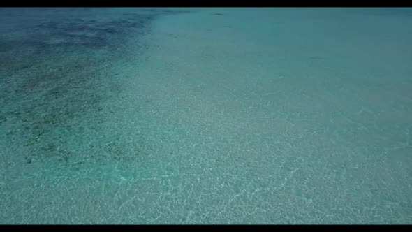 Aerial drone shot sky of marine coast beach adventure by blue lagoon and white sandy background of a