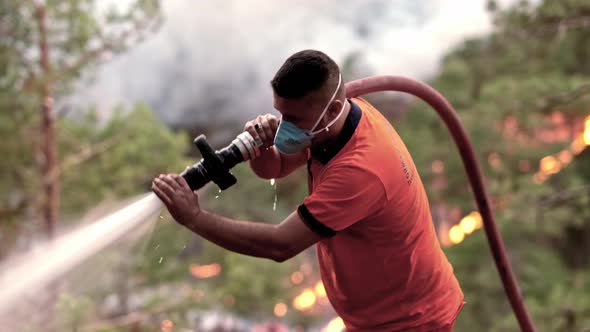 Firefighters Spray Water to Wildfire