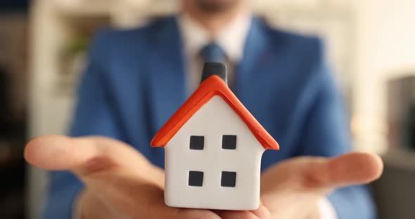 Man in Suit and Tie Holding Toy House in His Hands  Movie