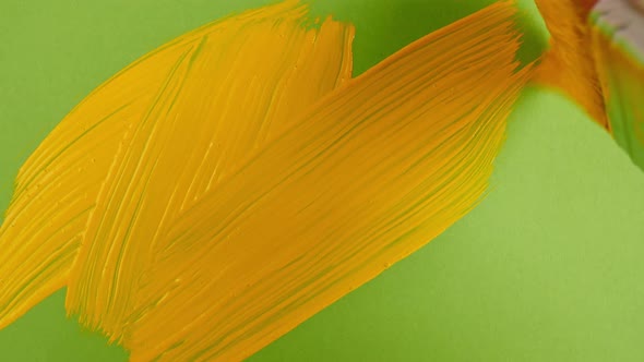 Yellow Acrylic Paint on a Green Background